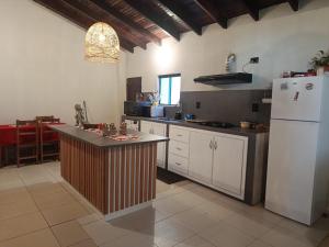 a kitchen with a white refrigerator and a counter at The Mango House in Caaguazú