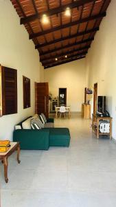 a living room with a green couch and a table at Recanto nas Montanhas em Mulungu in Mulungu
