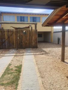 a house with a fence and a hammock on it at Edicula do Sidnei in Brotas