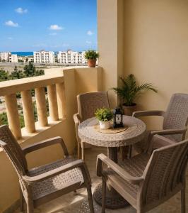 a table and chairs on a balcony with a view at New Coast Chalets -K77 in Dawwār Muḩammad Abū Shunaynah