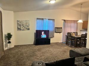a living room with a woman on a television at Central Comfort Duplex in Moses Lake