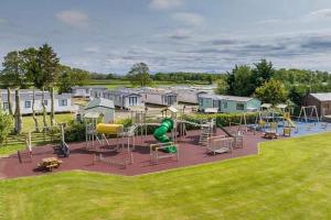a park with a playground with slides and play equipment at Ruby'scumbrianholidaysforall SEN friendly in Carlisle