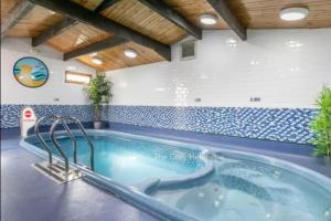 a jacuzzi tub in a room with blue and white tiles at Ruby'scumbrianholidaysforall SEN friendly in Carlisle