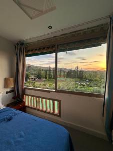 a bedroom with a bed and a window with a view at Jnane Ayam Atlas in Ourika +94 photos