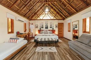 ein großes Zimmer mit zwei Betten und einer Couch in der Unterkunft Tay Beach Hotel Tayrona in Buritaca