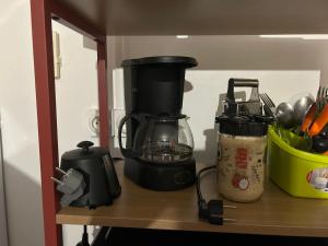 a kitchen counter with a coffee maker on a shelf at Villa SCAYOU in Pointe-Noire