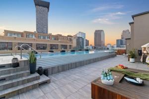 a rooftop patio with a swimming pool on top of a building at Corner Penthouse w Private Balcony Hotel Suite in New Orleans