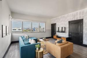 a living room with a blue couch and a table at Corner Penthouse w Private Balcony Hotel Suite in New Orleans