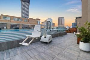 a white chair on the roof of a building with a pool at Corner Penthouse w Private Balcony Hotel Suite in New Orleans +45 photos