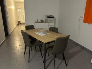 a wooden table with four chairs in a room at Villa SCAYOU in Pointe-Noire +11 photos