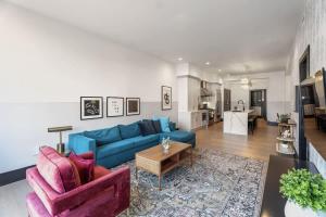 a living room with a blue couch and a table at LUX Suite Rooftop Pool Workspace Games Hotel in New Orleans