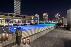 a swimming pool on top of a building with a city skyline at LUX Suite Rooftop Pool Workspace Games Hotel in New Orleans