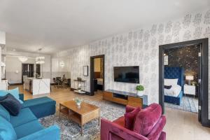 a living room with a blue couch and a living room with at LUX Suite Rooftop Pool Workspace Games Hotel in New Orleans