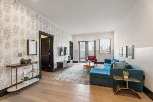 a living room with a blue couch in a room at LUX Suite Rooftop Pool Workspace Games Hotel in New Orleans +44 photos