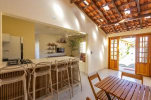 a kitchen with a bar and a table and chairs at Vila Tero 400 metros da praia de Boraceia in São Sebastião