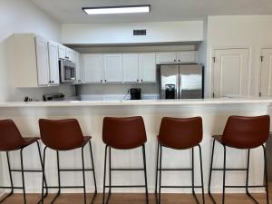 a kitchen with a bar with four stools at Wlk 2 MSU Fire Pit Pickleball Sleeps 8 in Starkville +33 photos