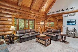 a living room with two couches and a table at Creekside Log Cabin - Fireplace - Mt Hood in Mount Hood Village