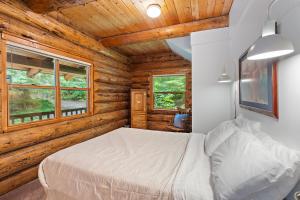 a bedroom with a bed in a log cabin at Creekside Log Cabin - Fireplace - Mt Hood in Mount Hood Village