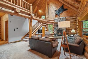 a living room with a couch and a fireplace in a log cabin at Creekside Log Cabin - Fireplace - Mt Hood in Mount Hood Village