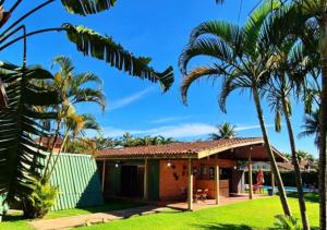 a house with palm trees in front of it at Pousada 4 Elementos Guaruja in Guarujá