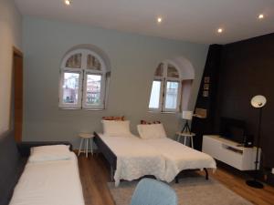 a bedroom with two beds and a tv and two windows at Oporto apartment Batalha in Porto