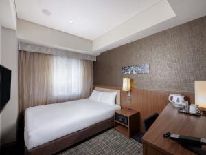 a hotel room with a bed and a desk at ibis Styles Tokyo Ginza in Tokyo
