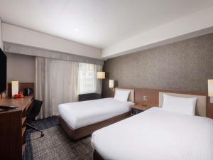 a hotel room with two beds and a television at ibis Styles Tokyo Ginza in Tokyo +59 photos