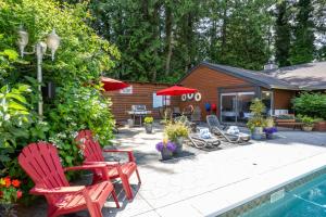 a yard with chairs and a pool and a house at Sunshine Lodge Inn in Gibsons