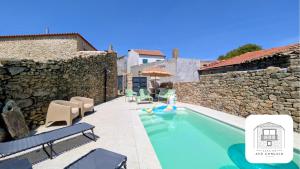 a villa with a swimming pool and a stone wall at Casa do Avô Gonçalo in Mogadouro