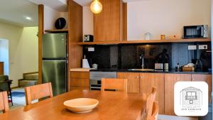a kitchen with a wooden table and a green refrigerator at Casa do Avô Gonçalo in Mogadouro