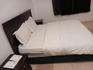 a bed with white sheets and pillows in a room at قصر أبها للشقق المفروشة in Abha