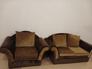 a brown couch and chair sitting next to a wall at قصر أبها للشقق المفروشة in Abha
