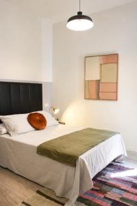 a bedroom with a bed with a orange pillow on it at Matute Street, Private rooms in Madrid +23 photos