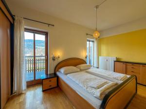 a bedroom with a large bed and a large window at Salburg Tröpolach in Tröpolach