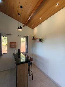 a kitchen with a counter and chairs in a room at Sakura da Mantiqueira in Paraisópolis