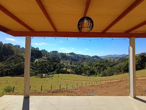a view of a field from the porch of a house at Sakura da Mantiqueira in Paraisópolis +7 photos