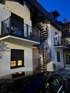 a black car parked in front of a building with balconies at The Central Passage in Gornji Milanovac