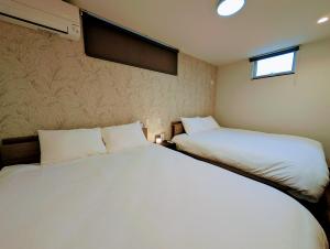 a bedroom with two beds and a window at Kawaguchiko Villa LaLuce in Fujikawaguchiko