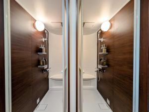 a bathroom with two toilets and wooden doors at Kawaguchiko Villa LaLuce in Fujikawaguchiko +37 photos