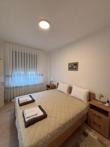 a bedroom with a large bed with two towels on it at The Central Passage in Gornji Milanovac