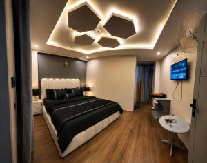 a bedroom with a black and white bed and a tv at Mall Rd Murree Ciros Hotel in Murree