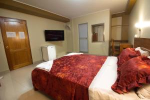 a bedroom with a large bed with a red blanket at Hotel Prince Selva Central in La Merced