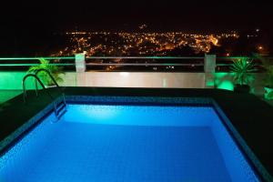a swimming pool with a view of a city at night at Hotel Prince Selva Central in La Merced +16 photos