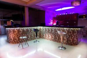 a bar with stools in a room with purple lighting at Hotel Prince Selva Central in La Merced