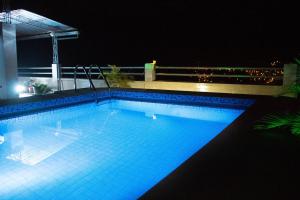 a swimming pool at night with the lights on at Hotel Prince Selva Central in La Merced