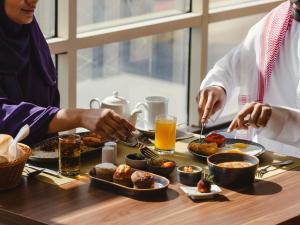a group of people sitting at a table eating food at Mercure Makkah Aziziah in Mecca