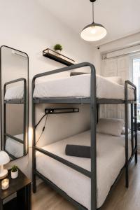 two bunk beds in a room with a lamp at Matute Street, Private rooms in Madrid