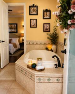 a bathroom with a tub with candles and a bedroom at Private Master suite with Sauna and Bathtub in Fair Oaks +2 photos