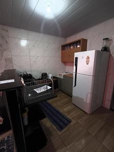 a small kitchen with a white refrigerator and a counter at casa 3 perto Carapina grande a 08 kilometros do aeroporto in Serra