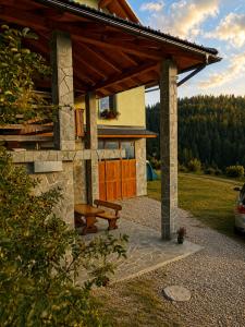 a house with a picnic table and a bench at Camping & Glamping Čenda in Železniki